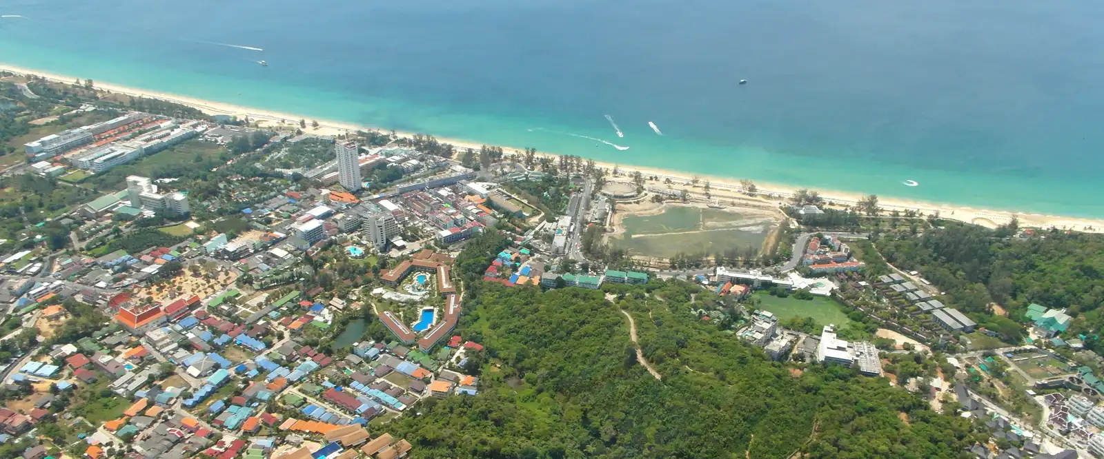 Karon from the air: the beach, the village behind it and the hills · Roma Neus, CC BY 3.0